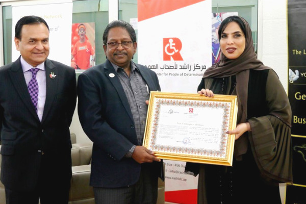 Prof. Christopher Abraham, Professor and Head of Campus (Dubai) at SP Jain School of Global Management,
(centre) receives a token of appreciation from Her Excellency Ms. Mariam Othman, Founder and CEO
of Rashid Centre for people of determination (right) in the presence of Dr. Tariq Nizami, Founder & CEO 
of CEO Clubs Network (left)